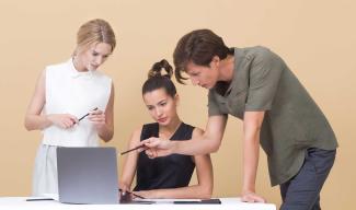 Three people looking at a laptop screen