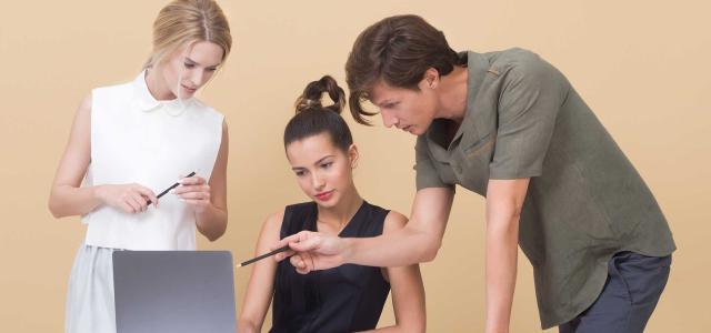 Three people looking at a laptop screen